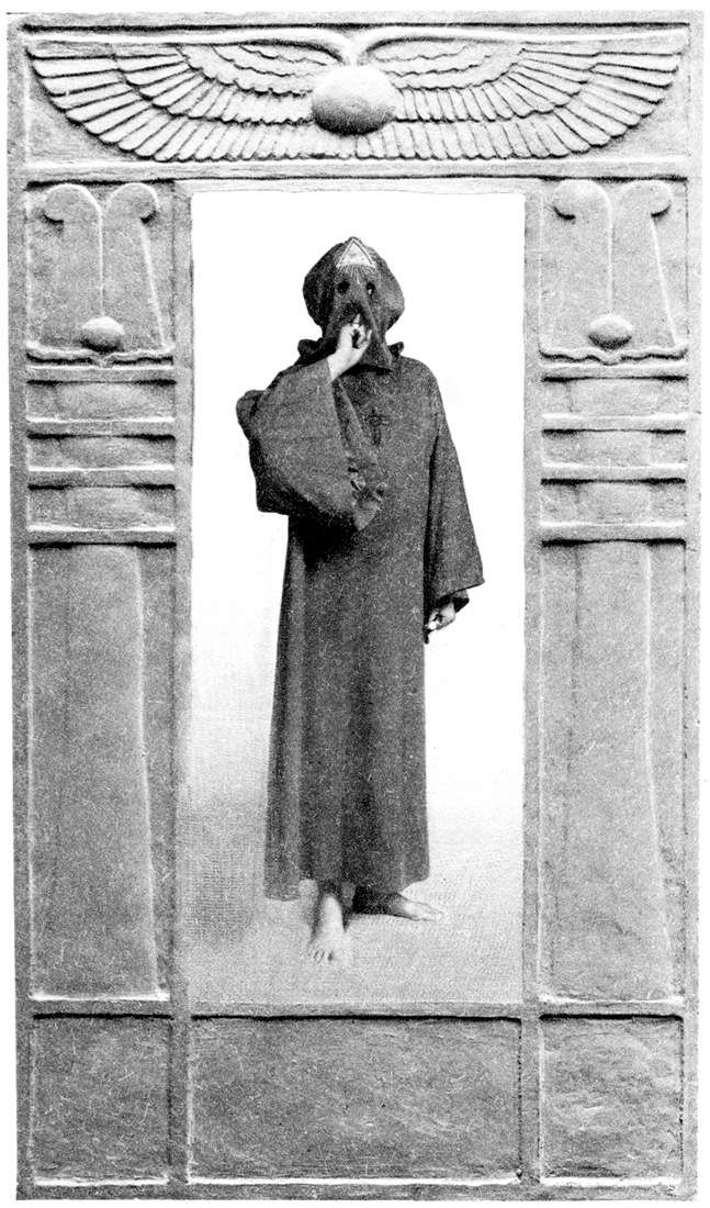Uma pessoa trajando o robe de Dominus Liminis e fazendo o Sinal do Silêncio em meio a um portal egípcio