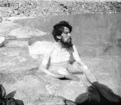 Aleister Crowley tomando banho em um lago de águas termais no alto de uma montanha.